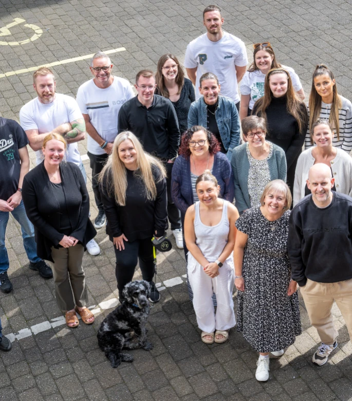 A group of people look up to the camera, smiling.
