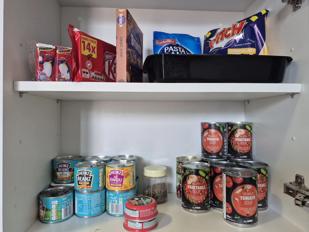 Kitchen hen cupboards, holding soup, beans, pasta, chocolates for parents